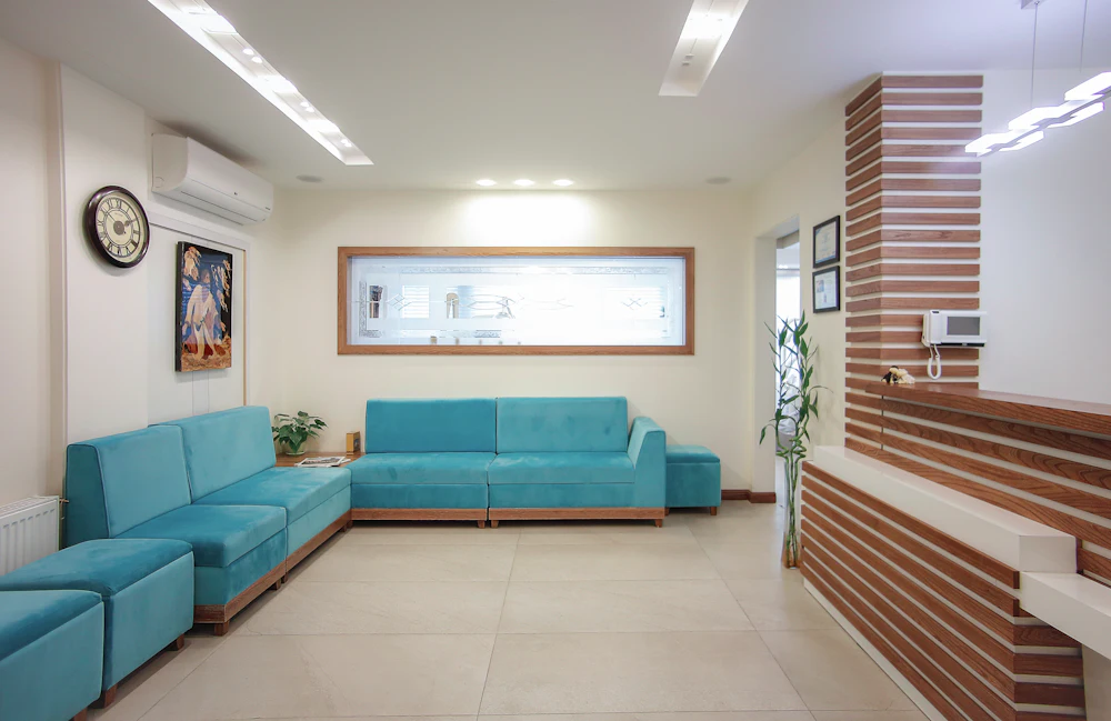 The clinic’s calm waiting area with teal sofas and plants