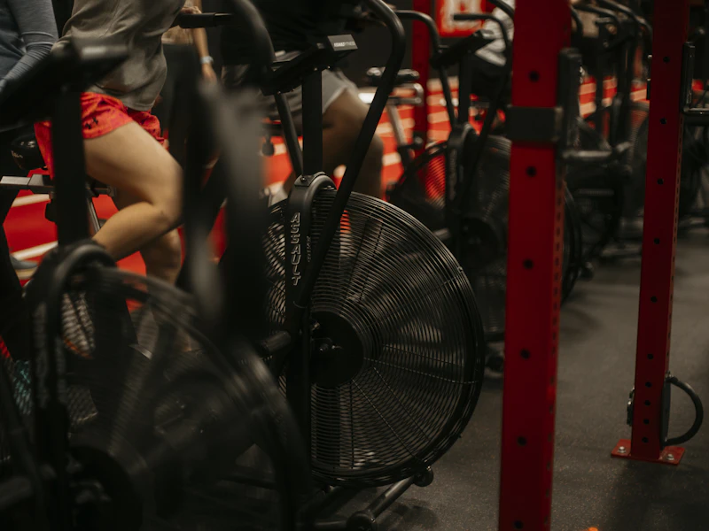Row of indoor bikes in a dimly lit spin studio
