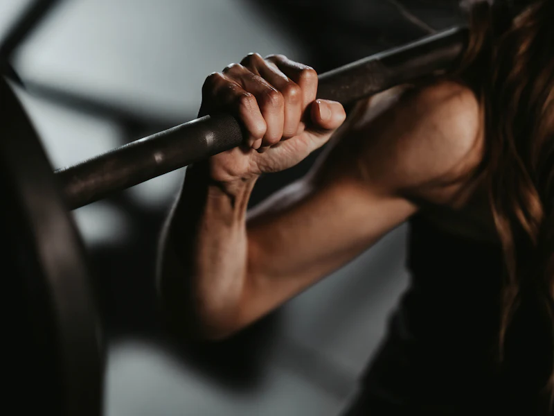 Close-up of a chalked hand gripping a loaded barbell