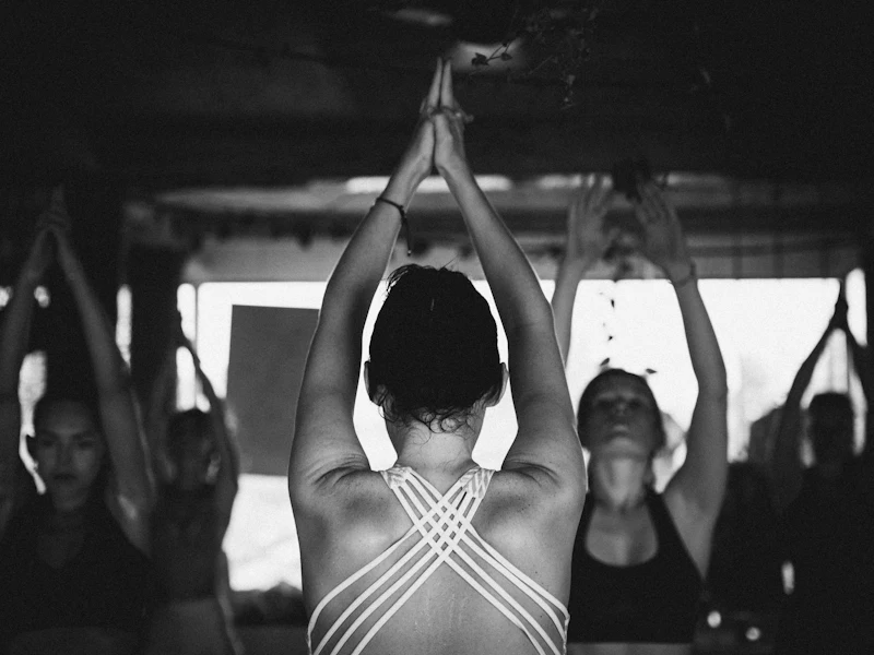 Group of women stretching their arms overhead in a yoga class