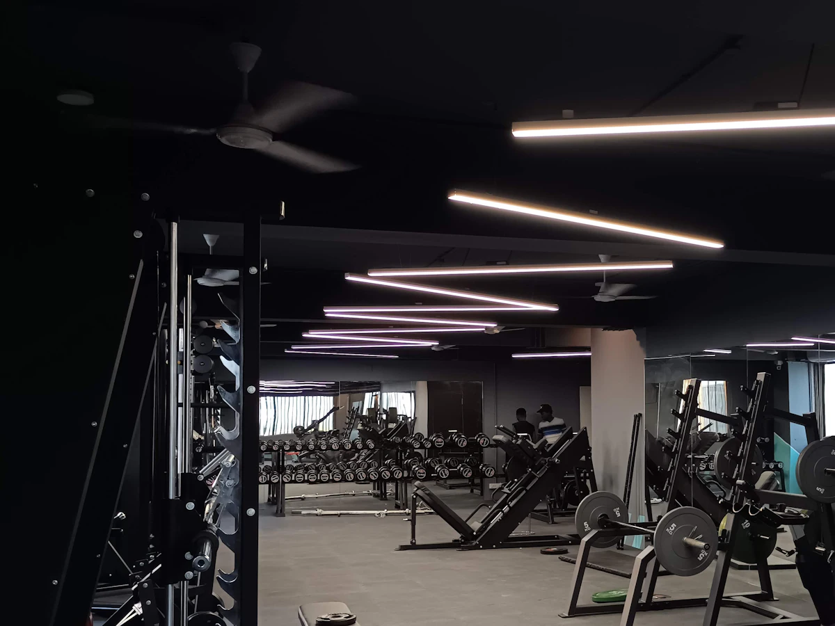 The FORGE training floor: racks, benches and cardio machines under strip lighting