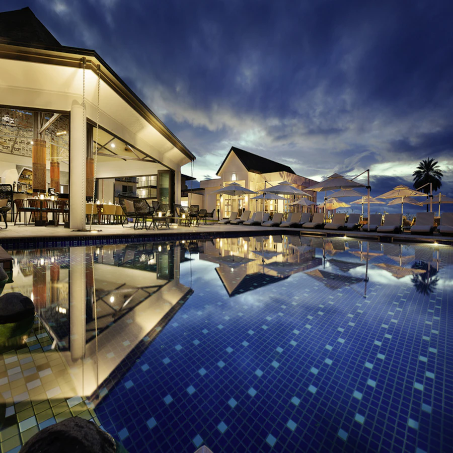 Glass-walled lounge opening onto the reflecting pool at dusk