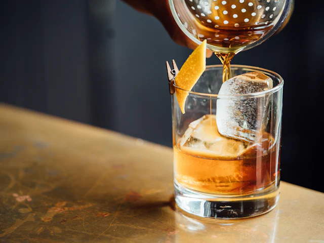 Cocktail being finished at the bar