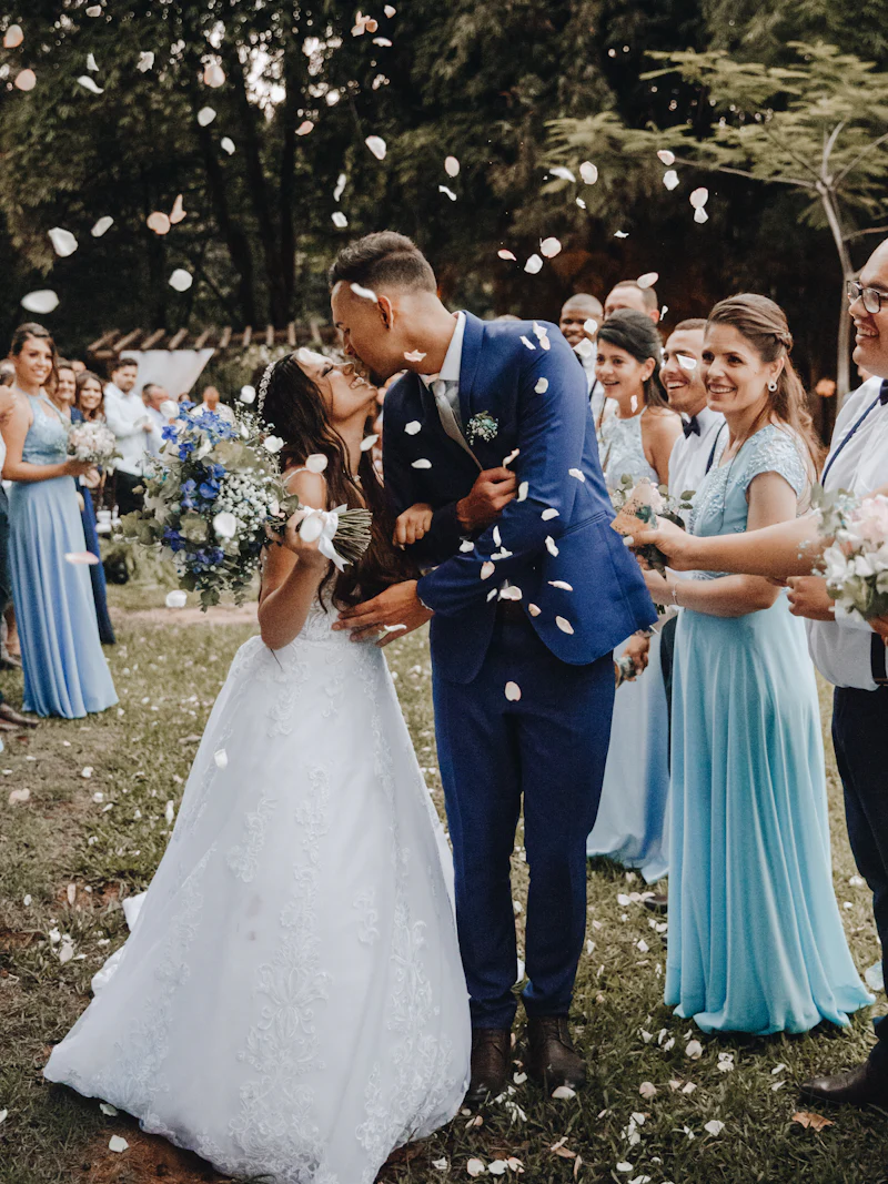 A couple kissing as guests throw confetti around them