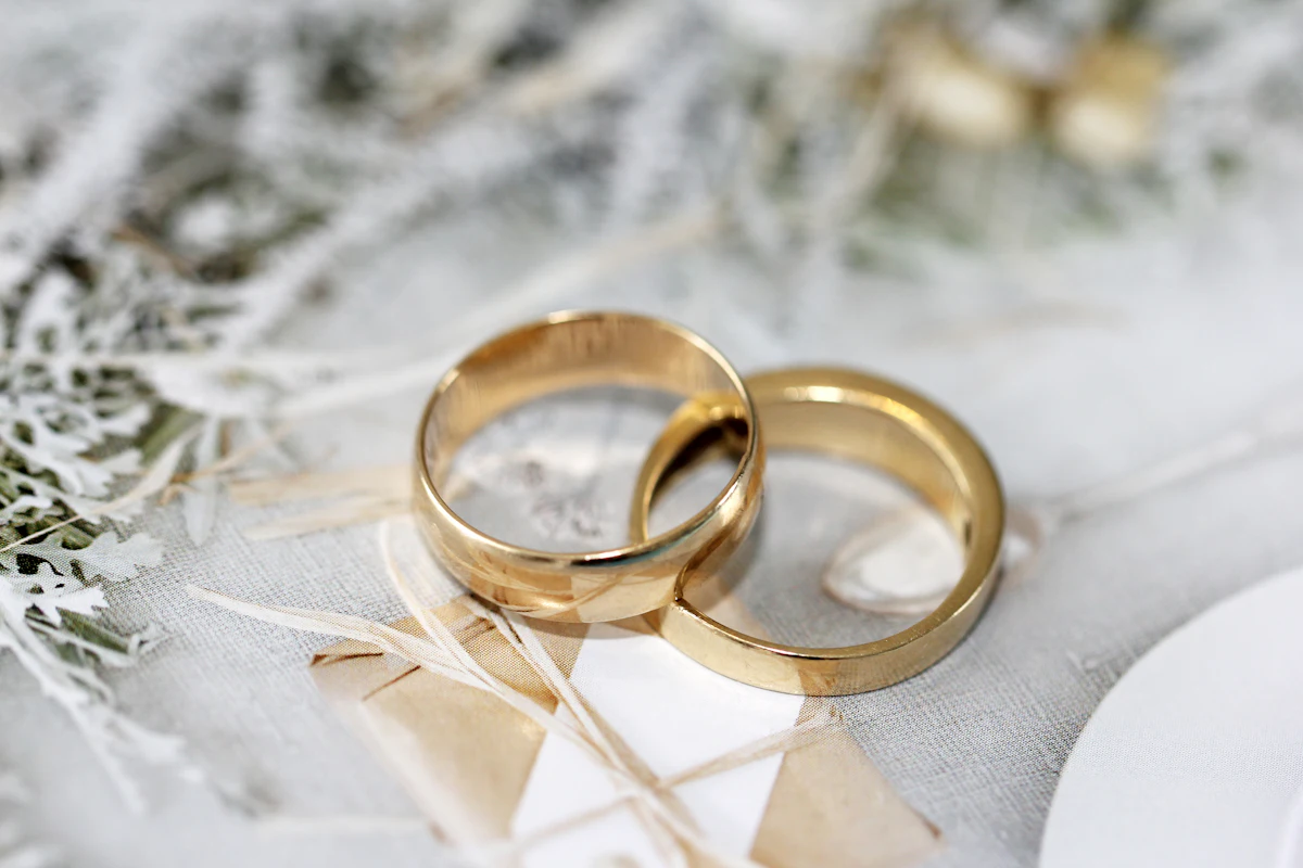 Two gold wedding bands resting on white lace