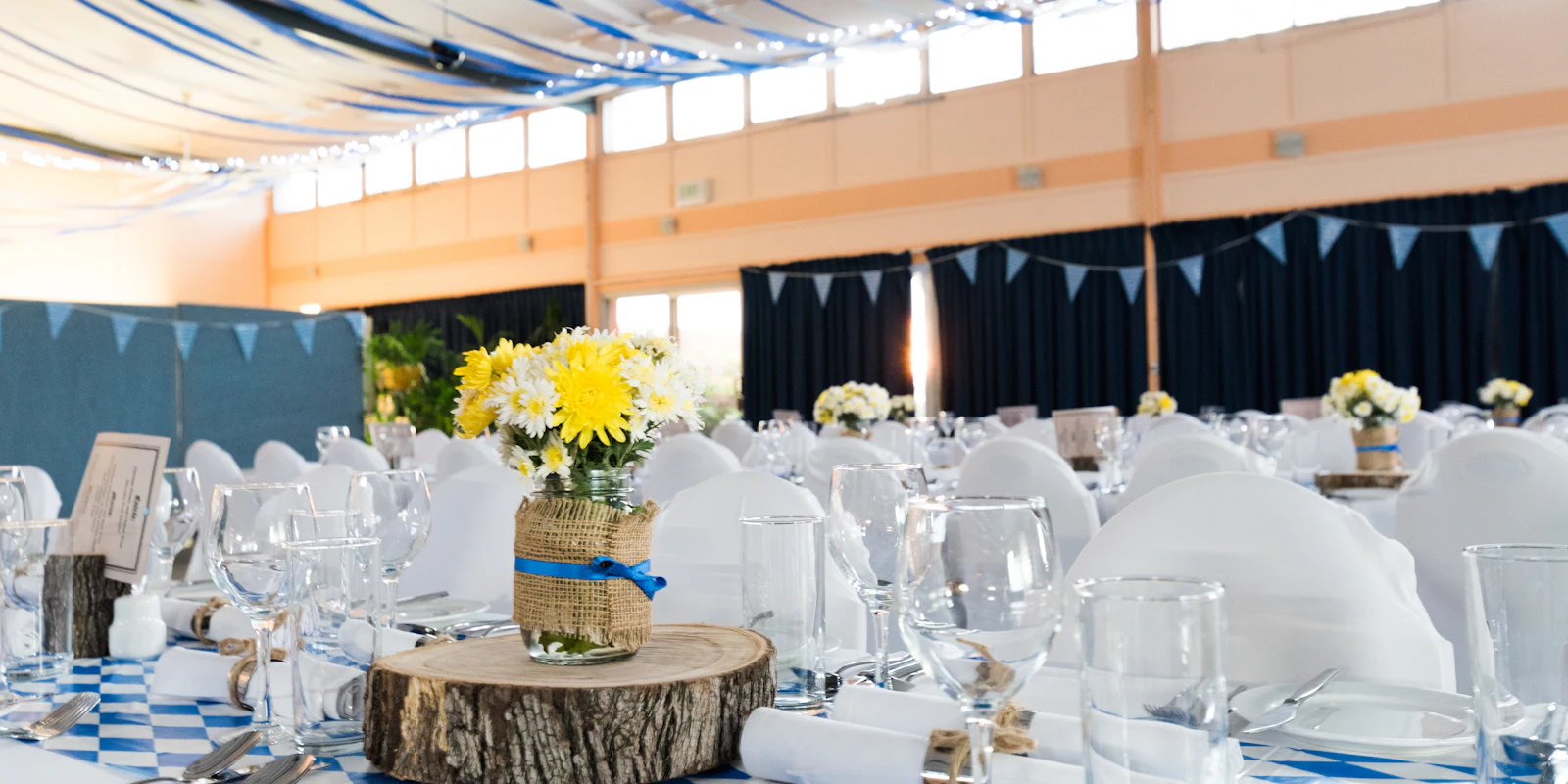 Reception hall with long tables, white linen and sunflower centrepieces