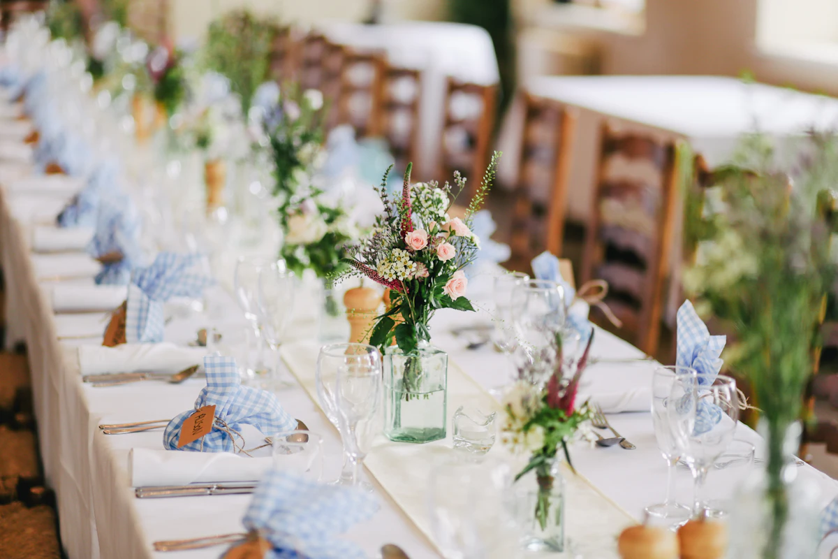 Long reception table with wildflower posies and blue napkins